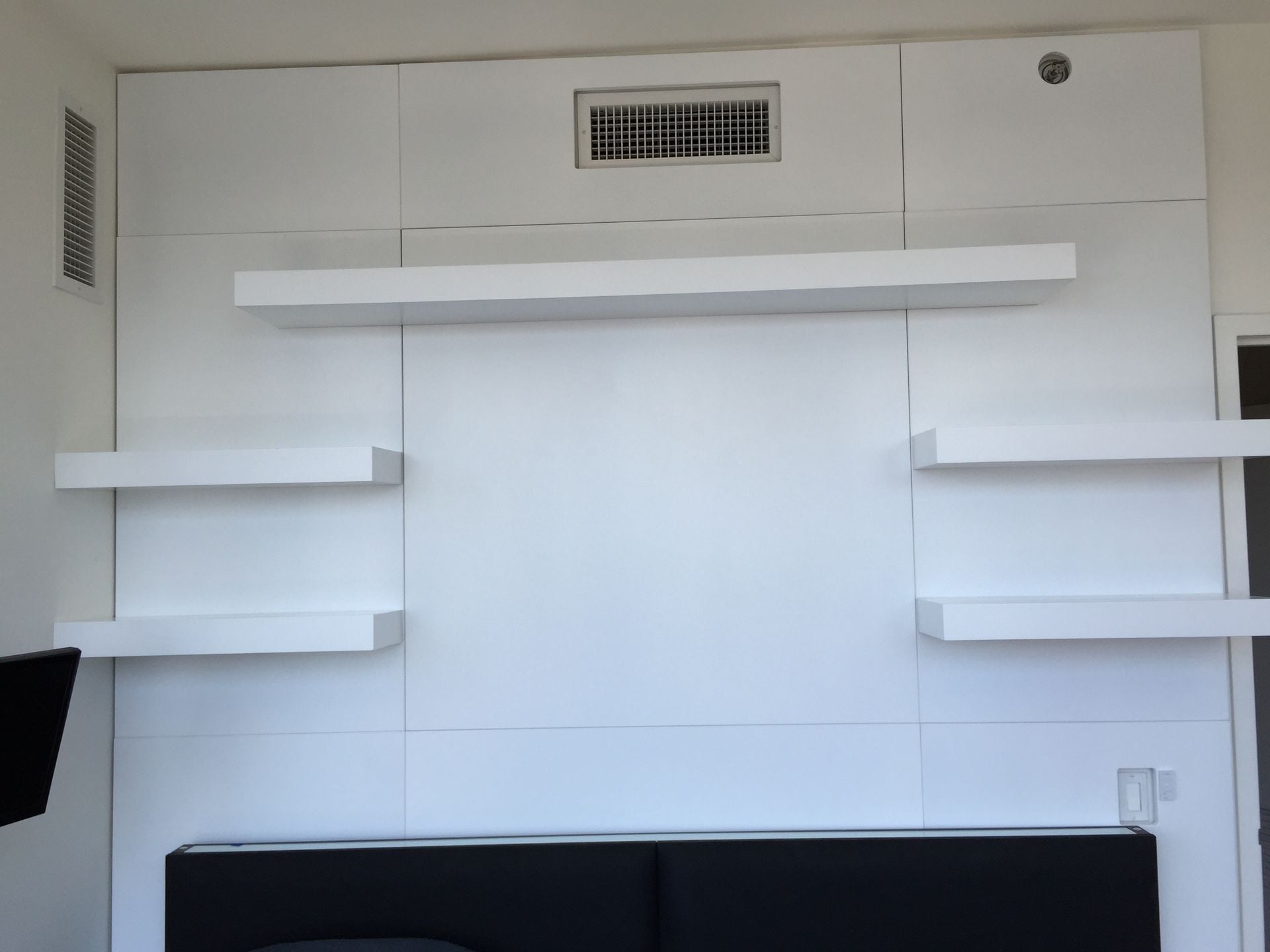 Wall Unit With Custom Paneling And Floating Shelves
